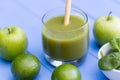 Healthy green smoothie drink with straw blue table background