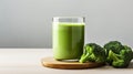 a healthy green smoothie, featuring broccoli, elegantly presented in a glass on a white wood background. The composition