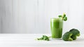 a healthy green smoothie, featuring broccoli, elegantly presented in a glass on a white wood background. The composition