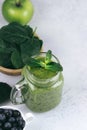 Healthy green smoothie in a glass jar and ingredients on white - spinach, apple and blueberry. Superfood, detox food Royalty Free Stock Photo