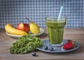 Healthy green smoothie with kale, strawberries, blueberries, banana, apple, pear and honey in a glass against a rustic wood backgr Royalty Free Stock Photo
