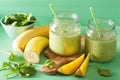 Healthy green smoothie with spinach mango banana in glass jars Royalty Free Stock Photo