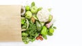 Healthy green vegan vegetarian food in full paper bag, vegetables and fruits on white background. Shopping food supermarket, raw Royalty Free Stock Photo