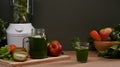 Green vegetable smoothie in glass and fresh vegetables on wooden table. Healthy food concept. Royalty Free Stock Photo