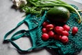 Healthy grocery goods. Flat-lay of net bag full of fresh organic vegetables, greens from local farmers market over