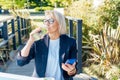 Healthy habit to drink water. Smiling middle aged business woman with bottle of water with lemon and mint during her Royalty Free Stock Photo