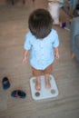 Healthy habits begin: Multiracial toddler weighing in at home