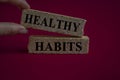 Healthy habits symbol. Concept word Healthy habits on brick blocks. Beautiful dark red background. Royalty Free Stock Photo