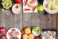 Healthy Halloween fruit snacks. Above view double border over a rustic wood background.