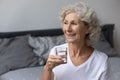 Healthy happy mature woman starting morning with drinking pure water