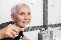 Healthy happy old elderly people brushing her teeth with toothbrush at bathroom in the morning,smiling asian senior showing white Royalty Free Stock Photo