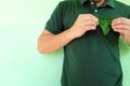 Healthy heart, love for environment and environmental conservationist concept. Young Asian man hands holding a green heart shape