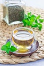 Healthy herbal mint tea in oriental glass cup with fresh peppermint and tea scoop on background Royalty Free Stock Photo