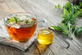 Healthy herbal tea cup, honey jar and medicinal herbs on wooden table Royalty Free Stock Photo