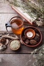 Healthy herbal tea preparation with glass asian teapot, candle. wooden and stone details and vintage rustic wooden background