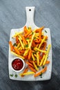 Healthy Homemade Baked Orange Sweet Potato and french Fries with ketchup, salt, pepper on white wooden board Royalty Free Stock Photo