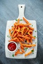 Healthy Homemade Baked Orange Sweet Potato Fries with ketchup, salt, pepper on white wooden board Royalty Free Stock Photo