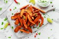 Healthy Homemade Baked Orange Sweet Potato wedges with fresh cream dip sauce, herbs, salt and pepper.