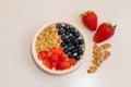 Healthy homemade breakfast. Yogurt with strawberries, blueberries and nuts in a bowl on a wooden white table. Top view. Royalty Free Stock Photo