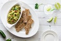 Healthy homemade guacamole served with rustic multigrain crackers.