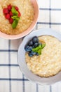 Healthy homemade oatmeal porridge with berries for breakfast in ceramic bowl on a checkered tablecloth. Royalty Free Stock Photo