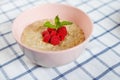 Healthy homemade oatmeal porridge with berries for breakfast in ceramic bowl on a checkered tablecloth. Royalty Free Stock Photo