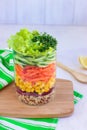 Healthy homemade salad with bulgur and vegetables in mason jar on wooden board with green napkin. Placed on white