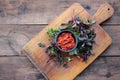 Healthy homemade tomato and red hot chili pepper sauce in a black bowl, and fresh basil on wooden board on table. Royalty Free Stock Photo