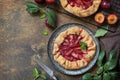 Healthy homemade wholegrain fruit pie, sweet crostata on a rustic table. Vegan vegetarian dessert, plums galette with almonds. Royalty Free Stock Photo