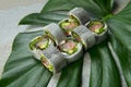 Healthy Japanese no rice sushi roll with raw fish fillet wrapped in daikon radish on monstera leaf, stone background Royalty Free Stock Photo