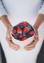 Healthy and juicy berries fruits in woman`s hands with white dress