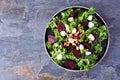 Healthy kale and beet salad with cheese and walnuts over a dark background