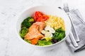 Healthy keto food concept. Fish salad bowl on marble background. Salad with salmon, couscous, vegetables, quail eggs Royalty Free Stock Photo