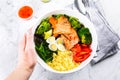 Healthy keto food concept. Fish salad bowl on marble background. Salad with salmon, couscous, vegetables, quail eggs Royalty Free Stock Photo