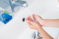 Healthy kid washing his hands under water in bathroom in morning Royalty Free Stock Photo