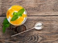 Healthy layered dessert with yogurt, banana, mango , cracker on wooden background, top view.