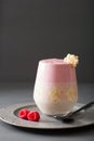 Healthy layered raspberry banana smoothie in glass