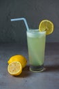 Healthy Lemon Juice limo pani fresh juice served in glass with lemon slice and straw side view on grey background