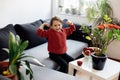 Healthy lifestyle concept - little adorable girl sitting on sofa, lots of fresh fruit on the table in front at home Royalty Free Stock Photo