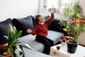 Healthy lifestyle concept - little happy child sitting on sofa, lots of fresh fruit on the table in front at home Royalty Free Stock Photo