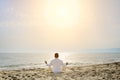 Healthy lifestyle concept - man doing yoga meditation exercises on the beach Royalty Free Stock Photo
