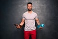 Lifestyle concept - portrait of shirtless muscular caucasian man holding a bottle of alcohol and a bottle of water