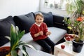 Healthy lifestyle concept - preschool girl sitting on sofa, lots of fresh fruit on the table in front at home Royalty Free Stock Photo