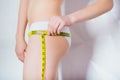 Healthy lifestyle concept - woman measures her waistline with a measuring tape in close-up.Sport girl measuring waist with yellow Royalty Free Stock Photo
