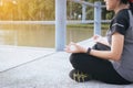 Healthy and lifestyle concept,Woman sitting practicing doing yoga exercise,workout after waking up at public park Royalty Free Stock Photo