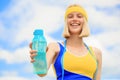 Healthy lifestyle concept. Woman in sportswear is holding a bottle of water. Young woman drinking water after run