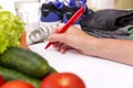 Healthy lifestyle concept. Writing weight loss plan with fresh vegetable diet and fitness