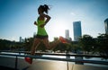 Fitness woman runner running on sunrise city