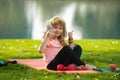 Healthy lifestyle and healthy food concept. Little boy child in sportswear with bottle water with thumb up sitting on Royalty Free Stock Photo