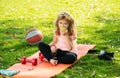 Healthy lifestyle and healthy food concept. Little boy child in sportswear eating apple sitting on sport mat after Royalty Free Stock Photo